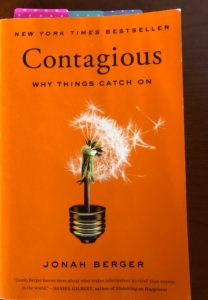Contagious book cover is in focus.